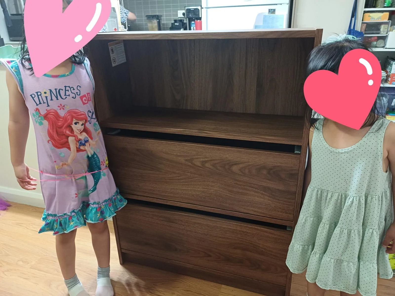 Libreria bassa IKEA in finitura noce con due ante a ribalta chiuse e vano superiore lasciato a giorno