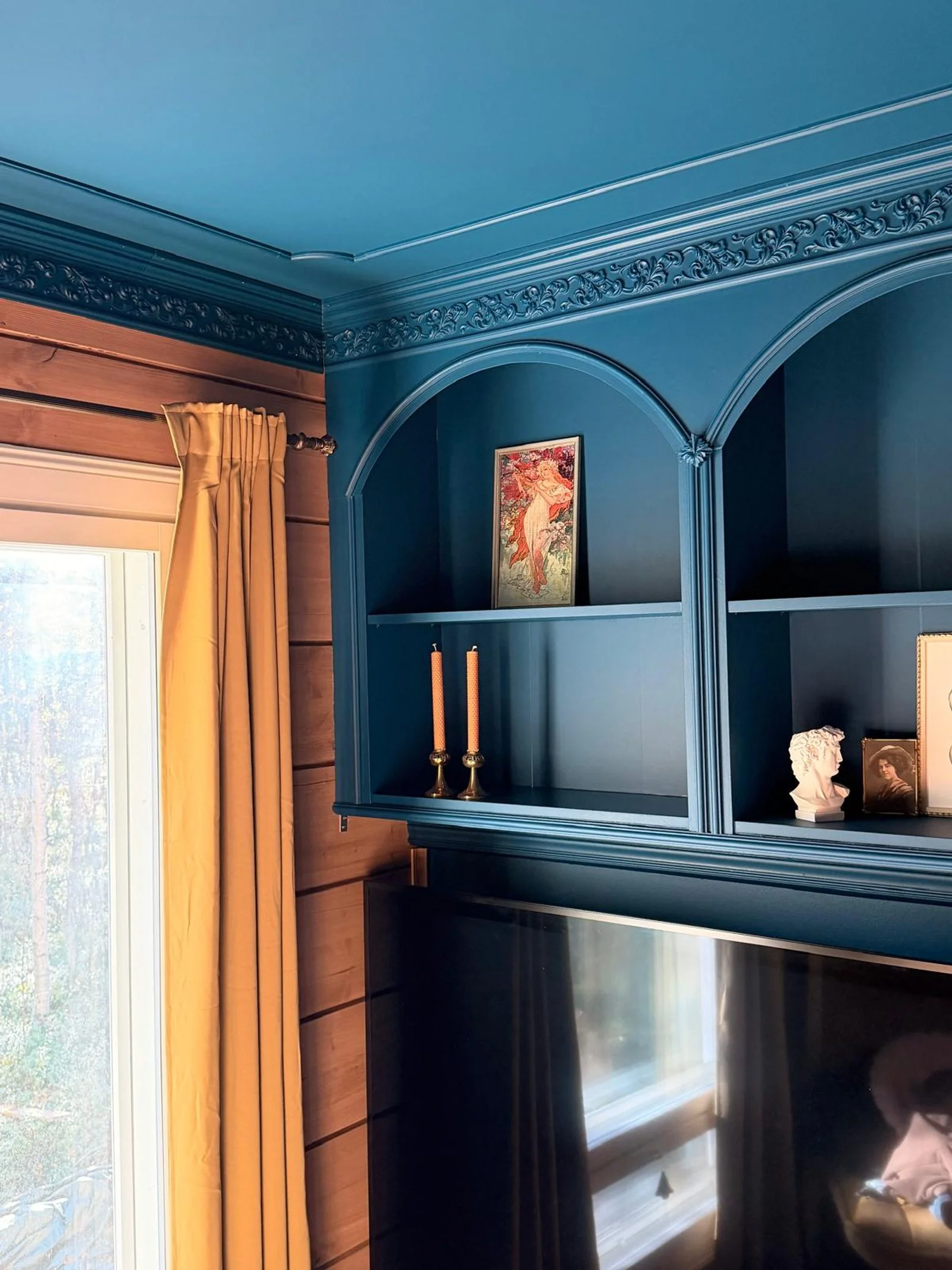 Dettaglio dei vani ad arco blu con cornice decorativa e raccordo al cornicione del soffitto