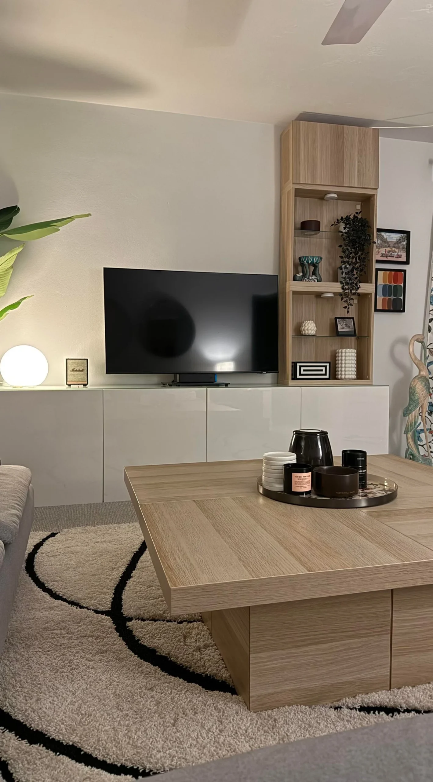 Vista di tre quarti del tavolino: piano continuo in rovere chiaro su base cieca a setti