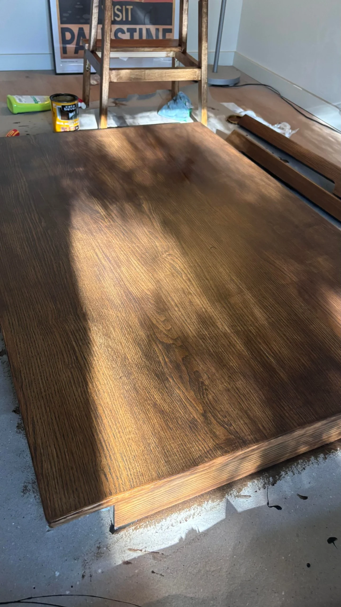 Piano di tavolo color noce illuminato di taglio dal sole, con venature e bordo in evidenza